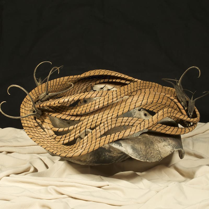 A sculpture of a hat made of twigs and sticks.
