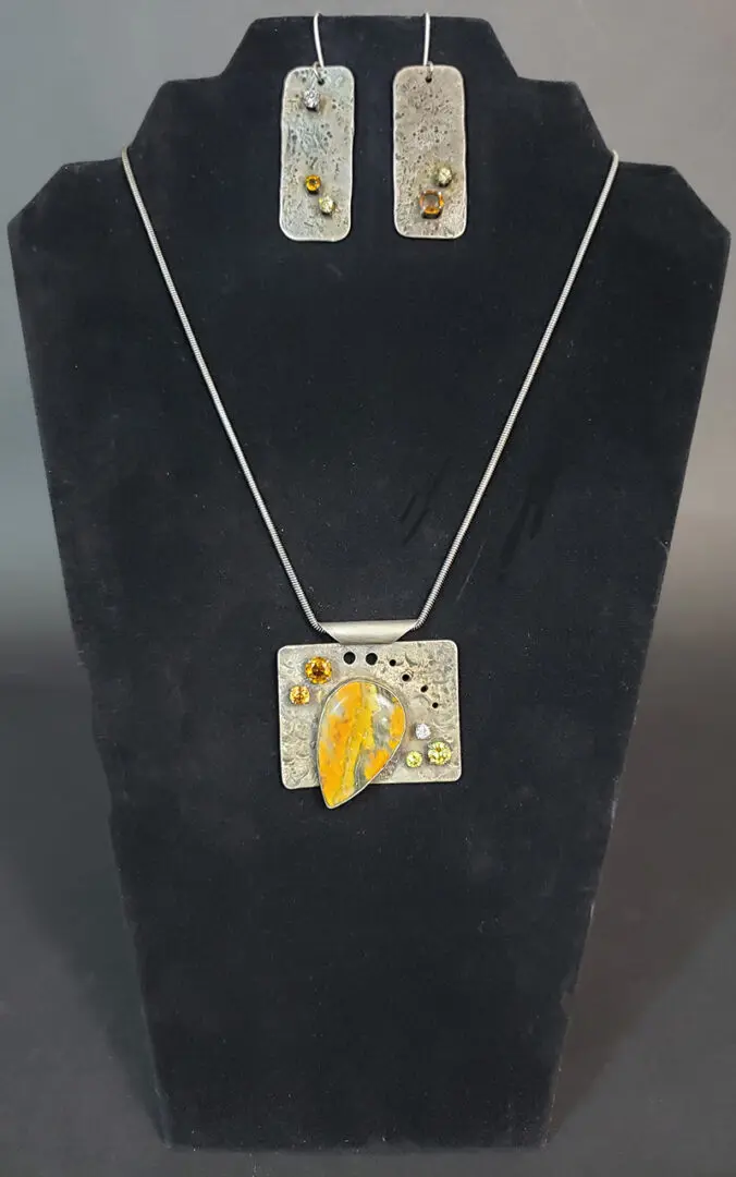 A necklace and earring set with yellow and silver.