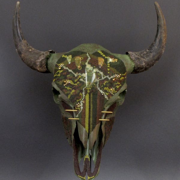 A cow skull with horns and flowers on it.