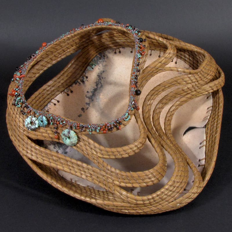 A woven basket with beads on it.