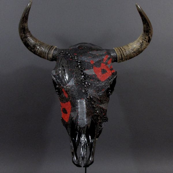 A skull with horns and red paint on it.