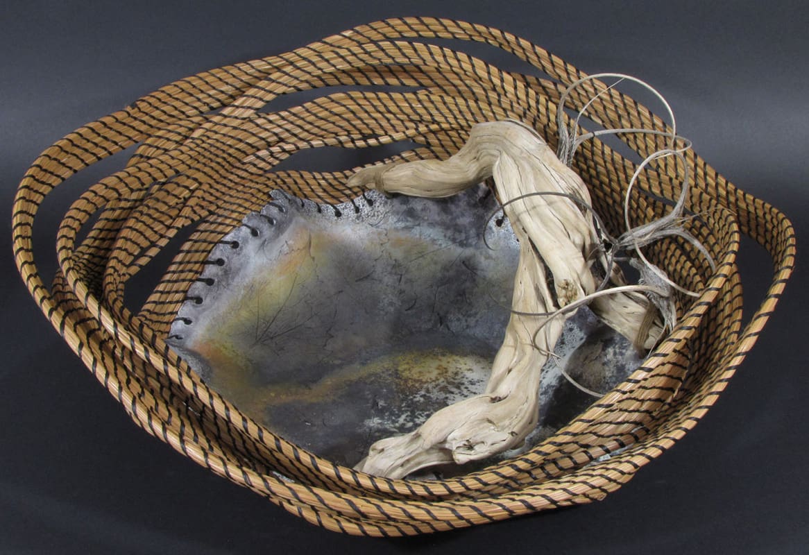 A basket with a piece of driftwood in it.