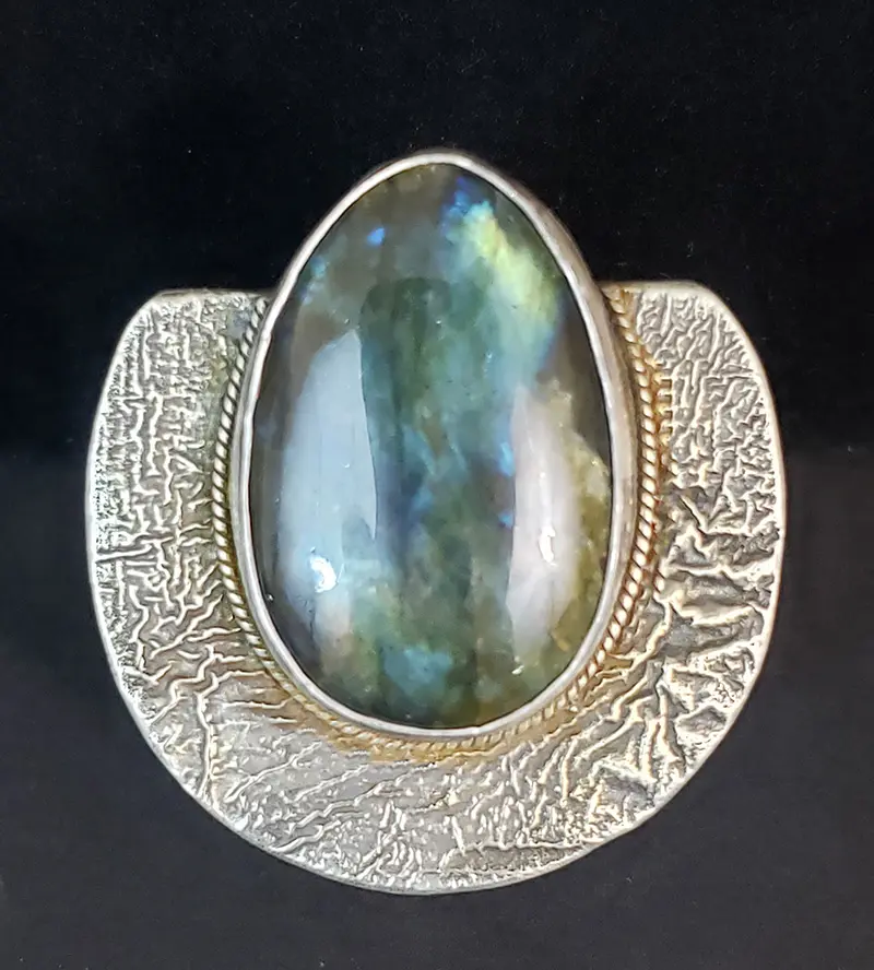A silver ring with a green labradorite stone.