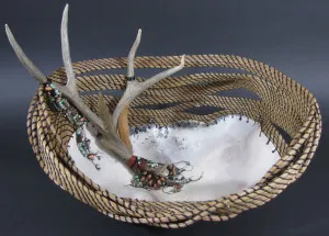 A wicker basket with deer antlers on it.