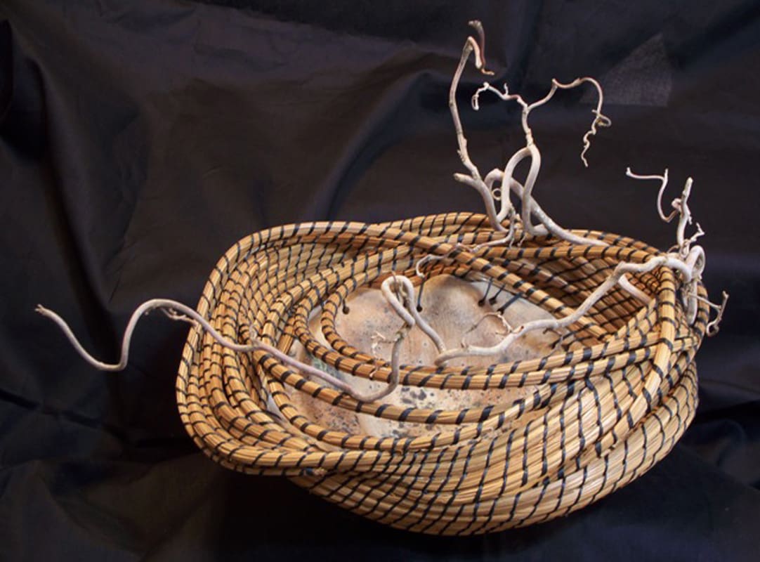 A woven basket with twigs in it.