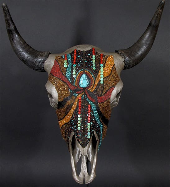 A bull skull with colorful beads and horns.