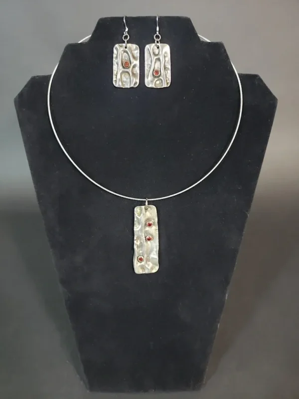 An Air Chased Sterling Silver With Garnets Necklace/Earrings Set, with red and white stones.