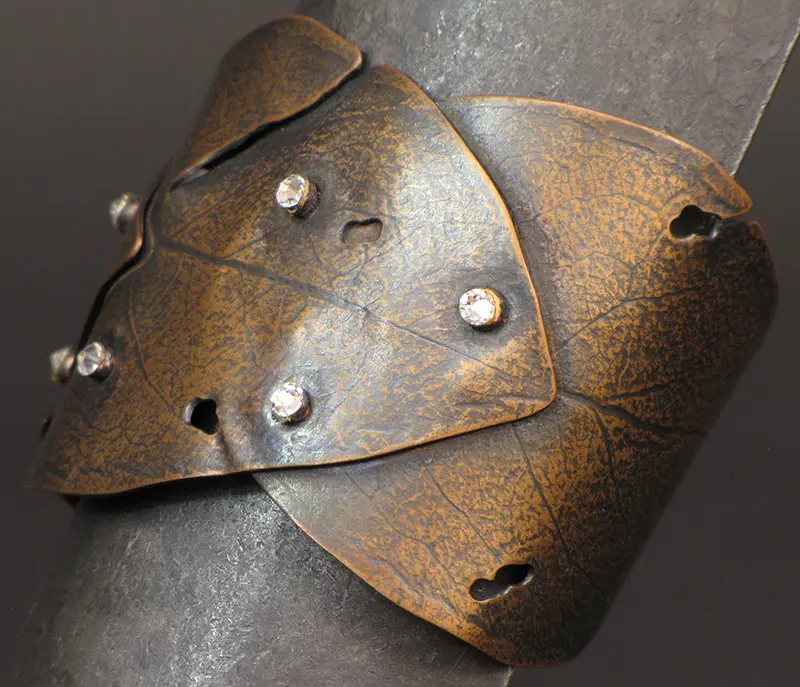 A brown leather cuff with studs on it.