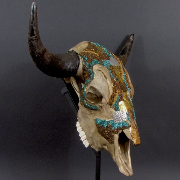 A bull skull with turquoise beading and horns.