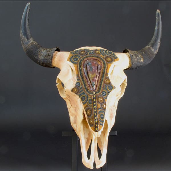 A cow skull with horns on a stand.