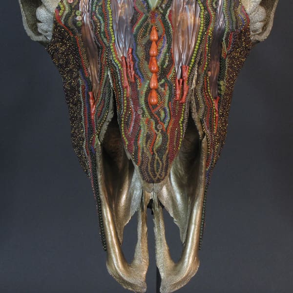 A Thantanjka sculpture of a deer skull with colorful designs on it.