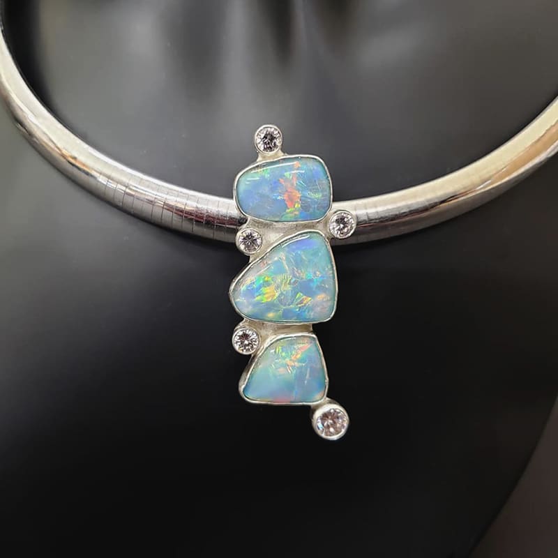 An opal and diamond necklace on a mannequin.