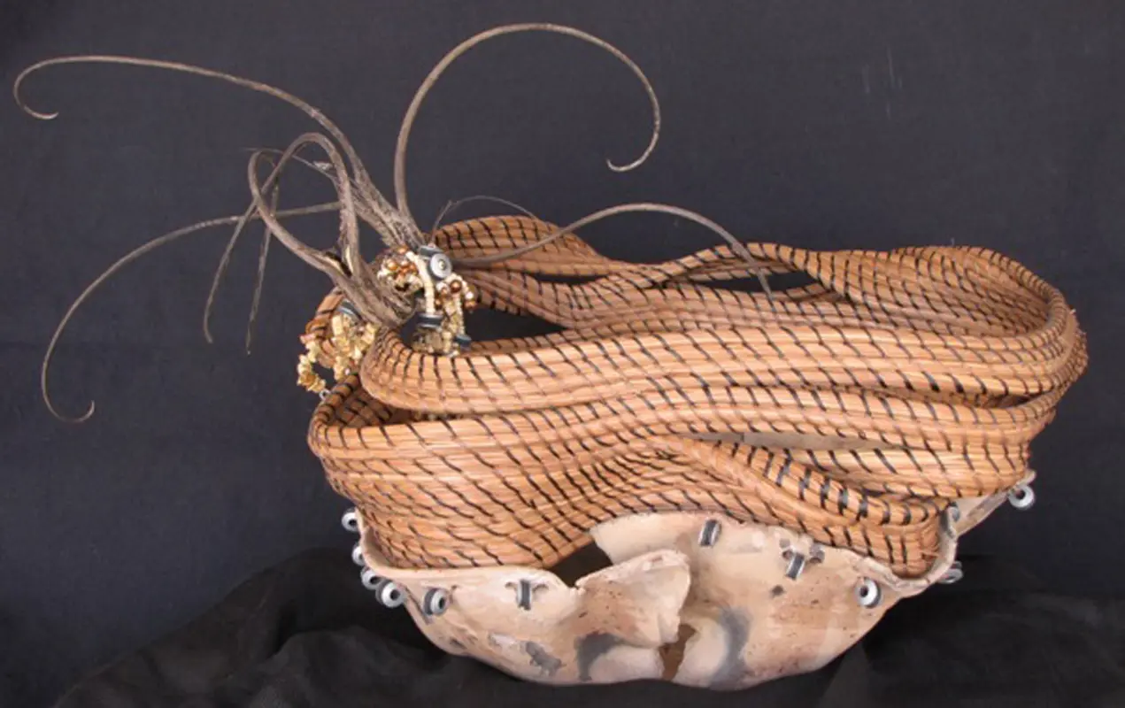 A woven basket with a lot of feathers on it.