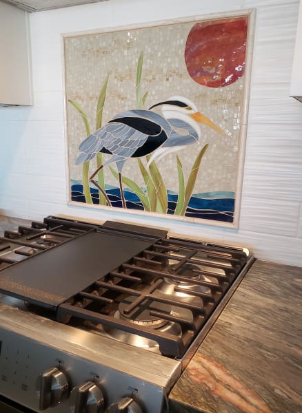 A kitchen with a blue heron on the stove top.