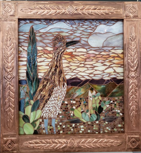 An image of a roadrunner in a copper frame.