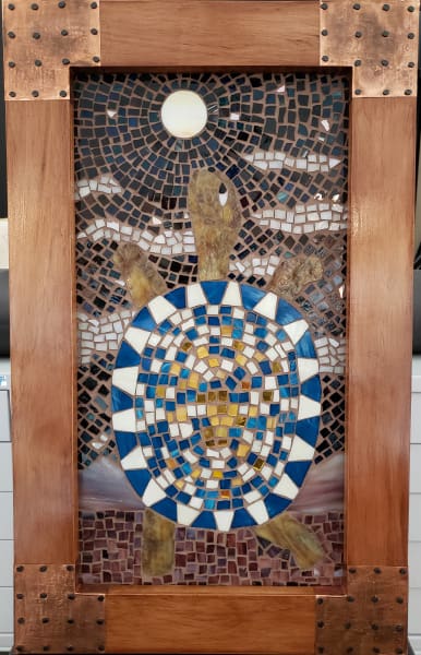 A mosaic turtle in a wooden frame.
