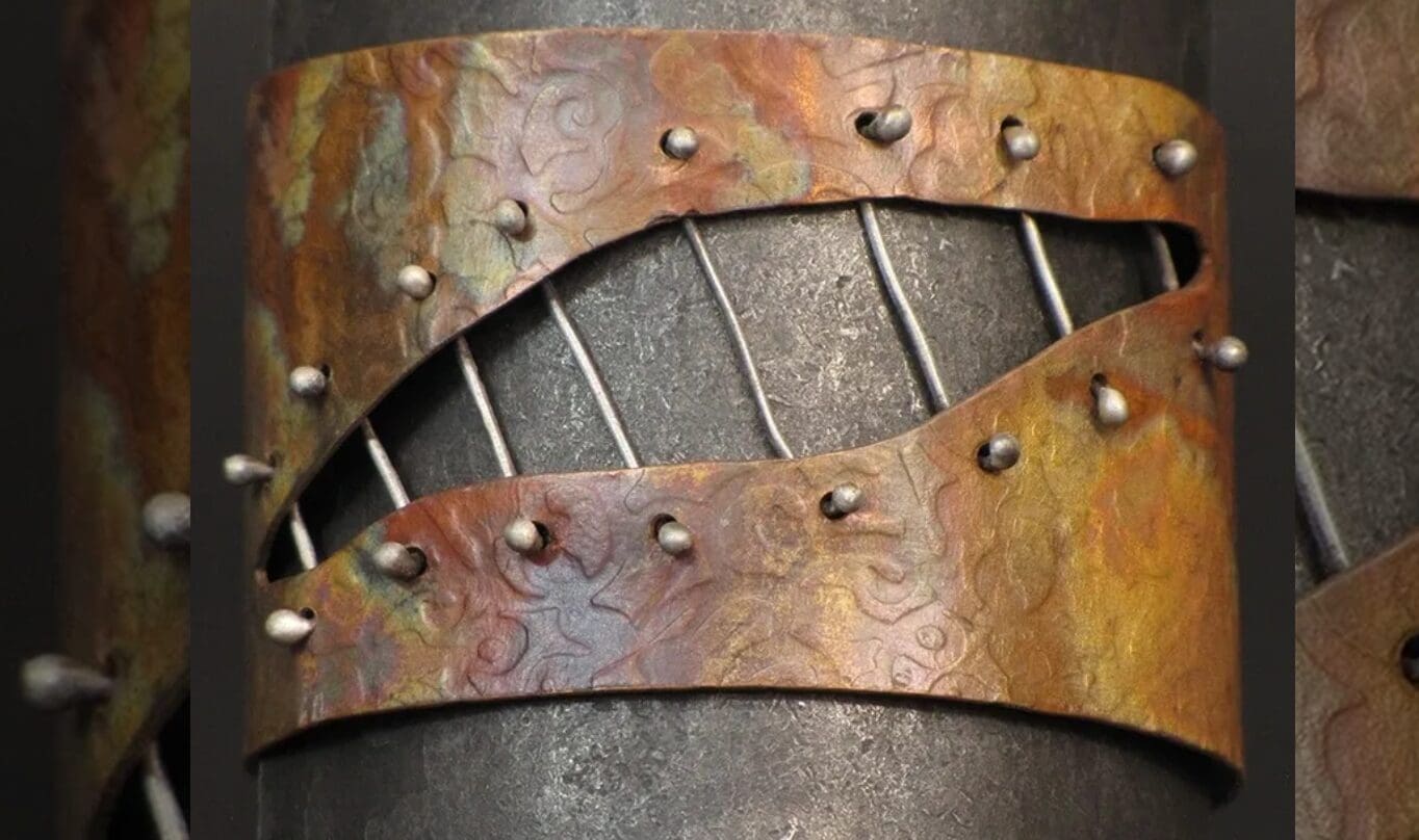 A metal sculpture of a guitar with rivets.