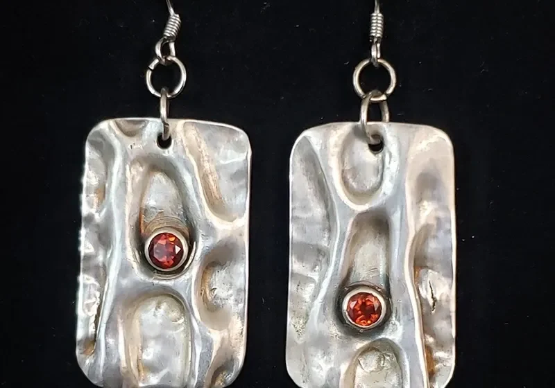 A pair of Air Chased Sterling Silver With Garnets earrings.
