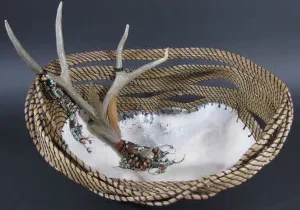 A wicker basket with deer antlers on it.