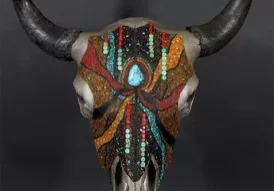 A bull skull with colorful beading on it.